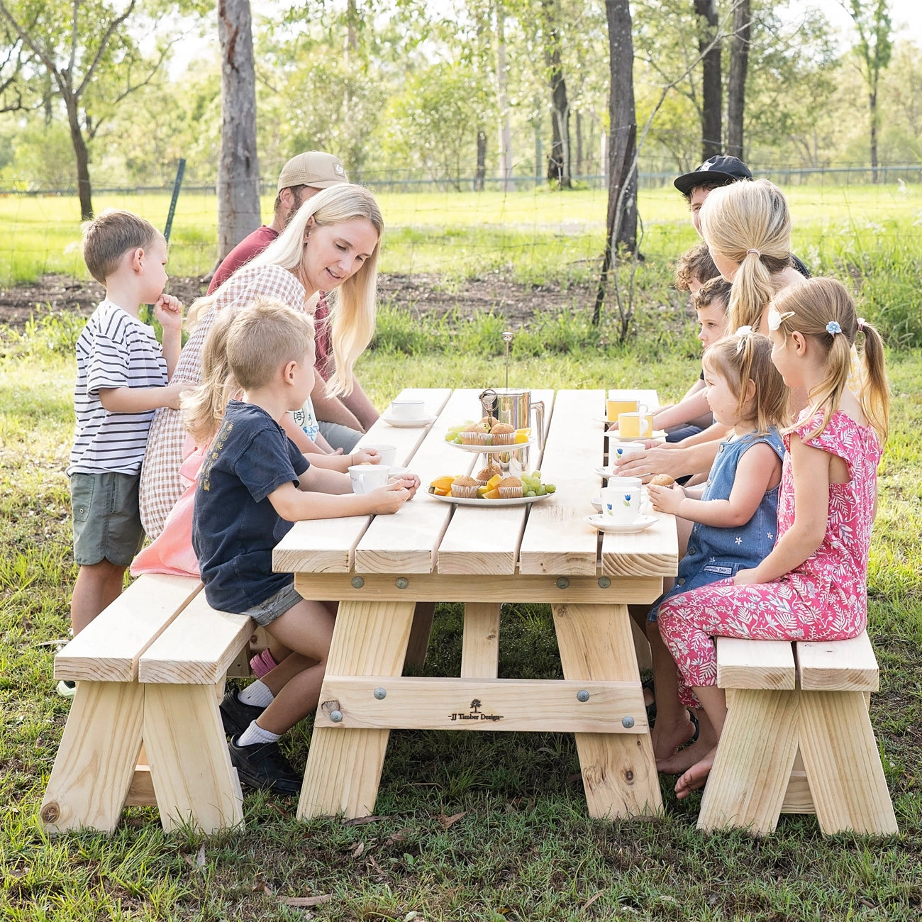 Children enjoying tea time together at JJ Timber kids picnic table outdoors.