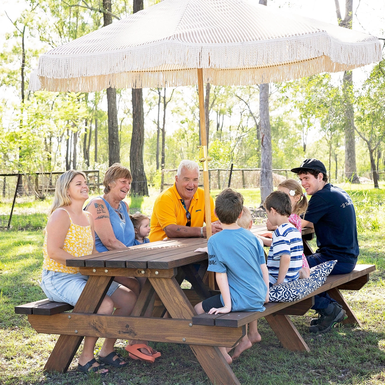 Outdoor lifestyle scene showing family enjoying JJ Timber 2.4m heavy duty picnic table.