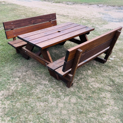 A dark brown wooden picnic table with two attached benches, photographed outdoors on a grassy lawn. Childs Table JJ Timber Design