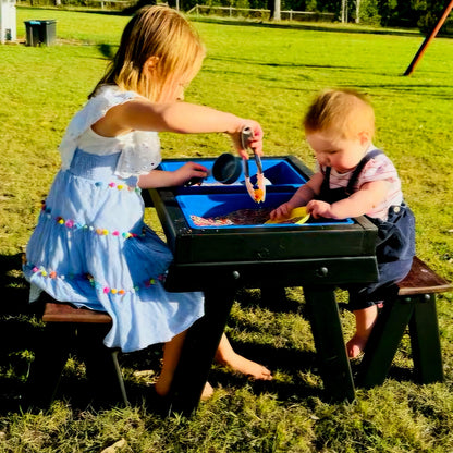 Two children playing together at a JJ Timber Design blue-tub sensory table outdoors.