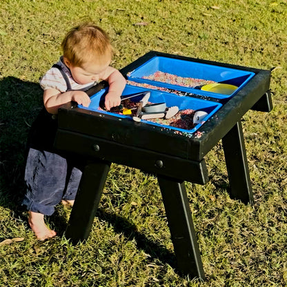 An infant playing with a handmade wooden sensory table By JJ Design