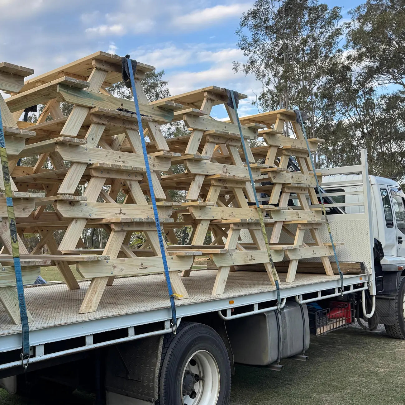 Bulk stack of JJ Timber Design picnic tables loaded for delivery.