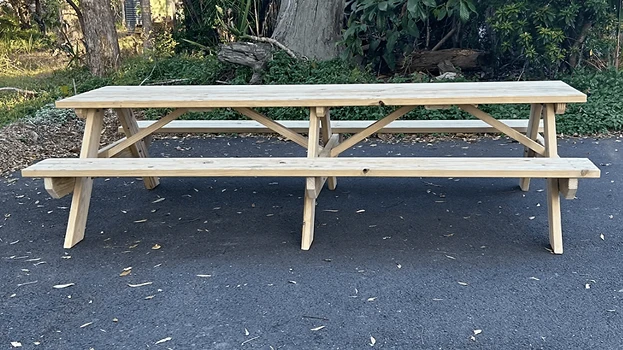 Extra-long natural timber picnic table by JJ Timber Design positioned outdoors with extended bench seating.