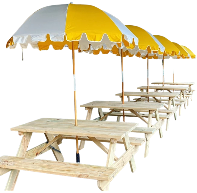 JJ Timber Design picnic tables arranged under large yellow umbrellas at café.