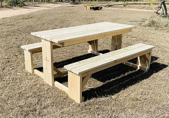 Light timber JJ Timber Design picnic table under shade trees.