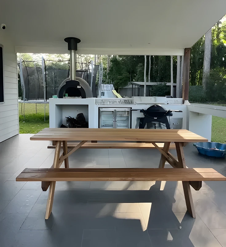 JJ Timber Design timber picnic table arranged on a patio with outdoor furniture.