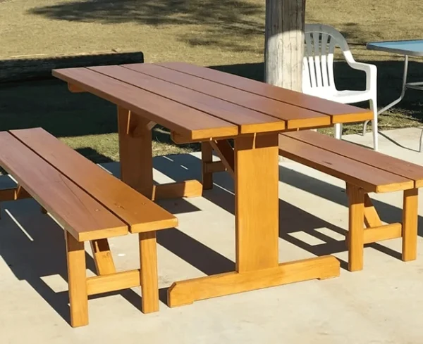 Two-tone JJ Timber Design picnic table set with matching bench seats in an outdoor area.