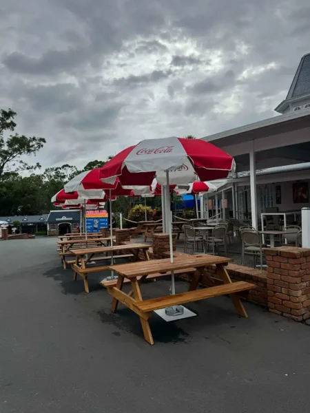 A custom timber picnic table aligned in an outdoor commercial seating layout