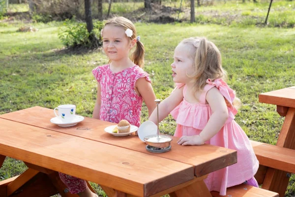 Two children enjoying tea time at JJ Timber kids picnic table outdoors.