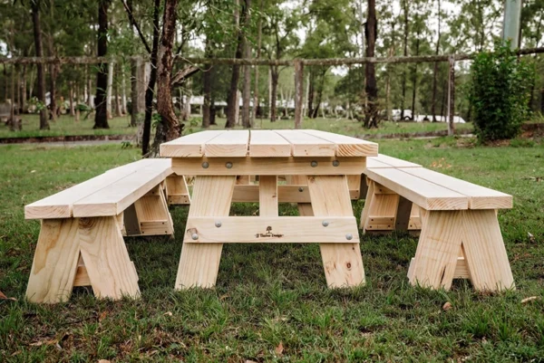 JJ Timber solid timber kids picnic table placed outdoors in natural garden setting.
